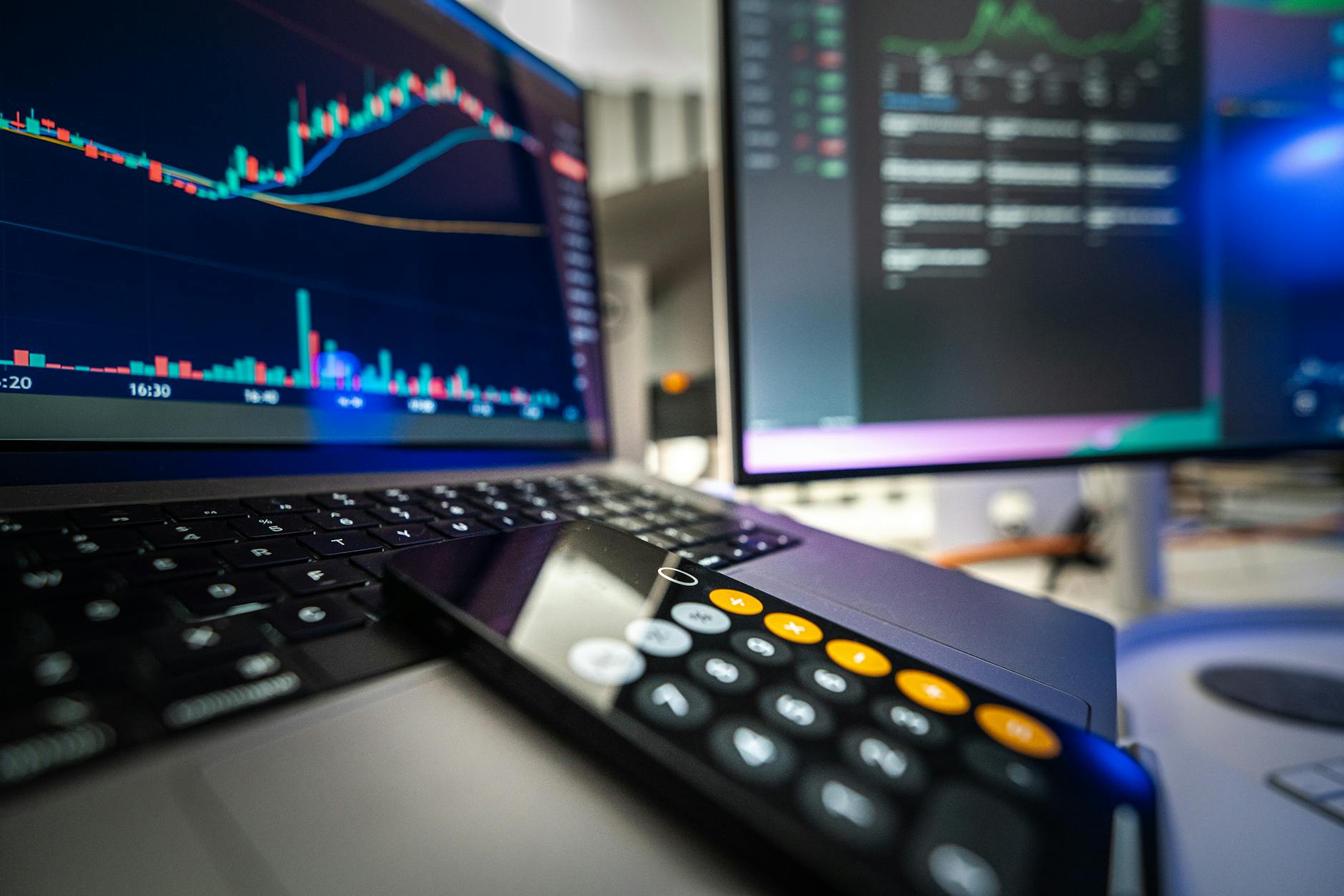Close-up view of financial analysis on laptop and screen with calculator for business strategy.