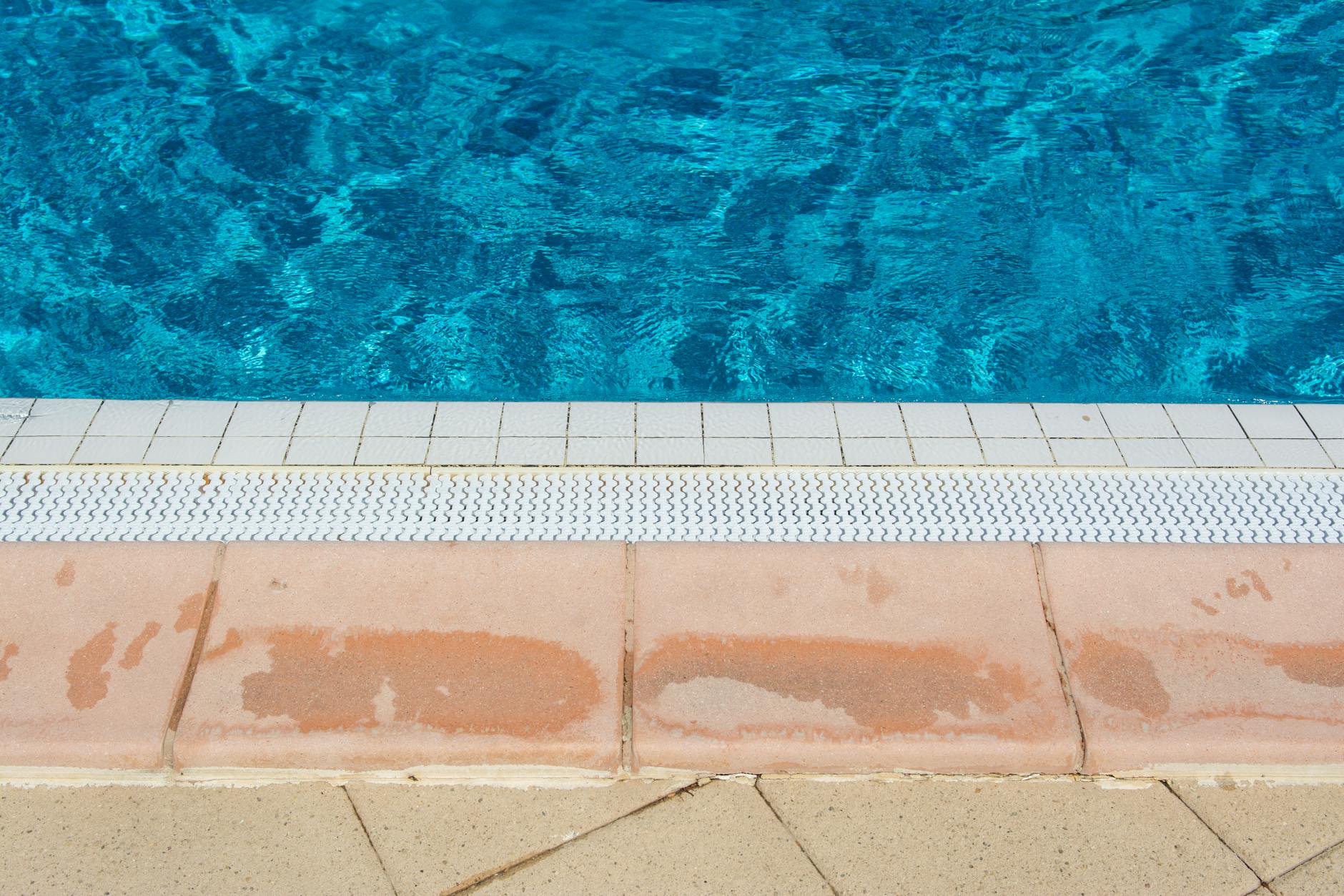 A bright image showcasing the inviting edge of a swimming pool under the summer sun.