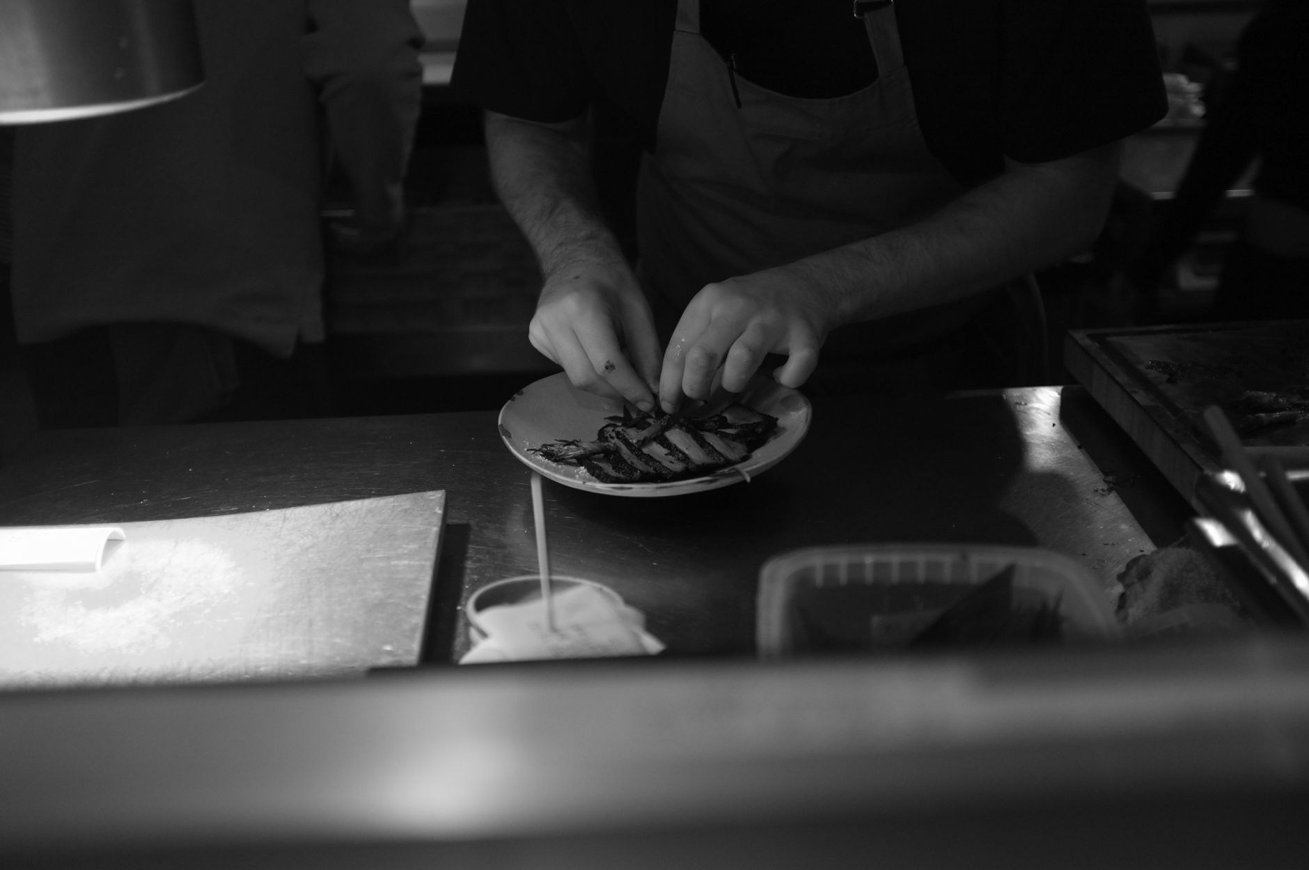 Chef preparando hambúrgueres gourmet em cozinha profissional