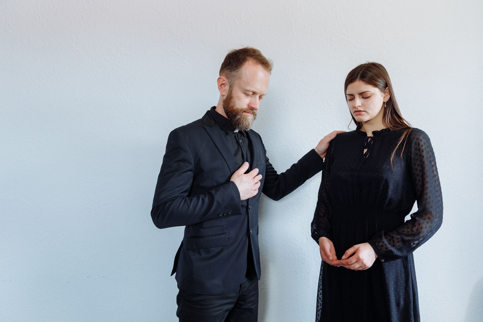 Priest offering support to grieving woman with a comforting gesture indoors.