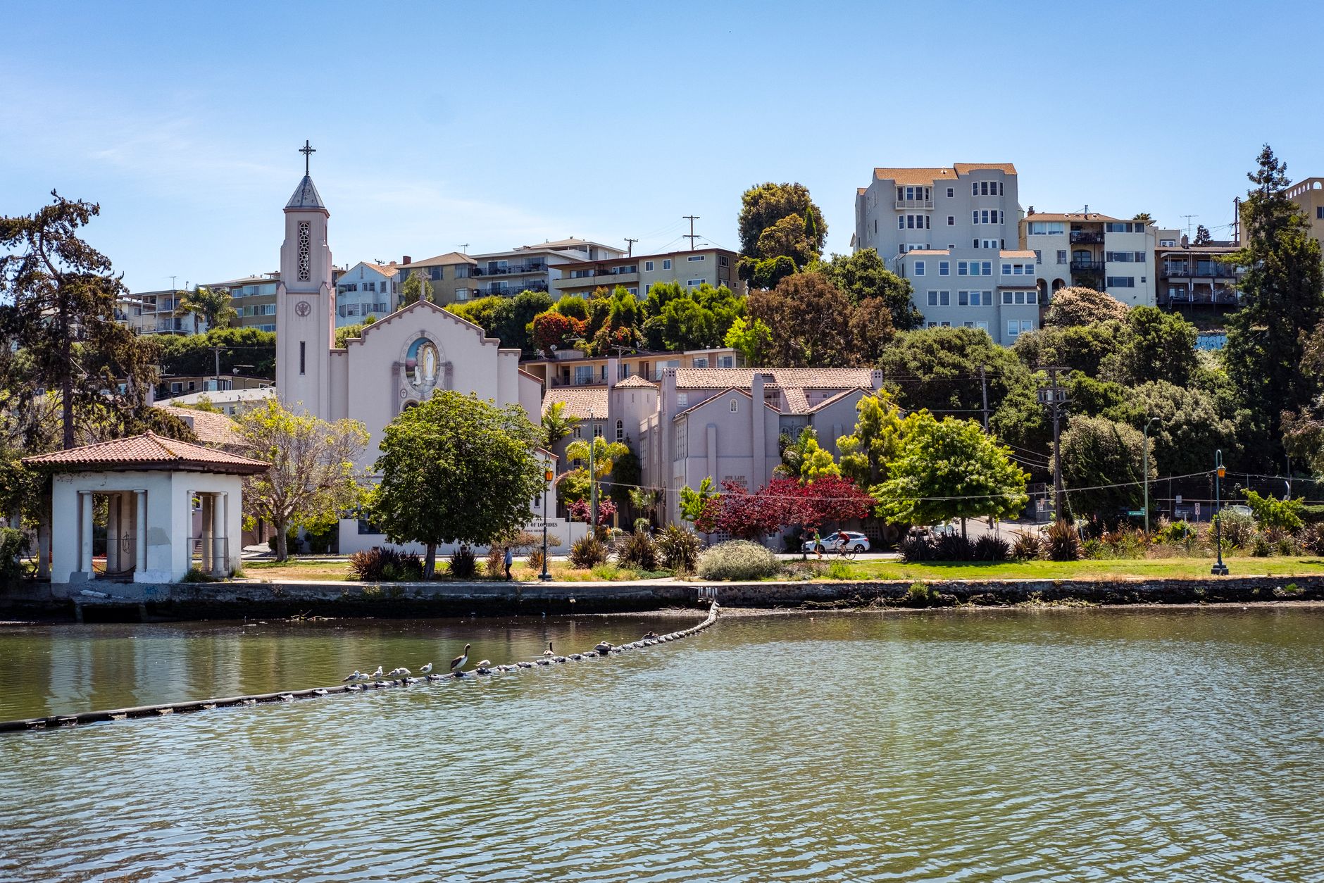 Beautiful view of Our Lady of Lourdes Church and surrounding buildings by the waterfront in Oakland, California.