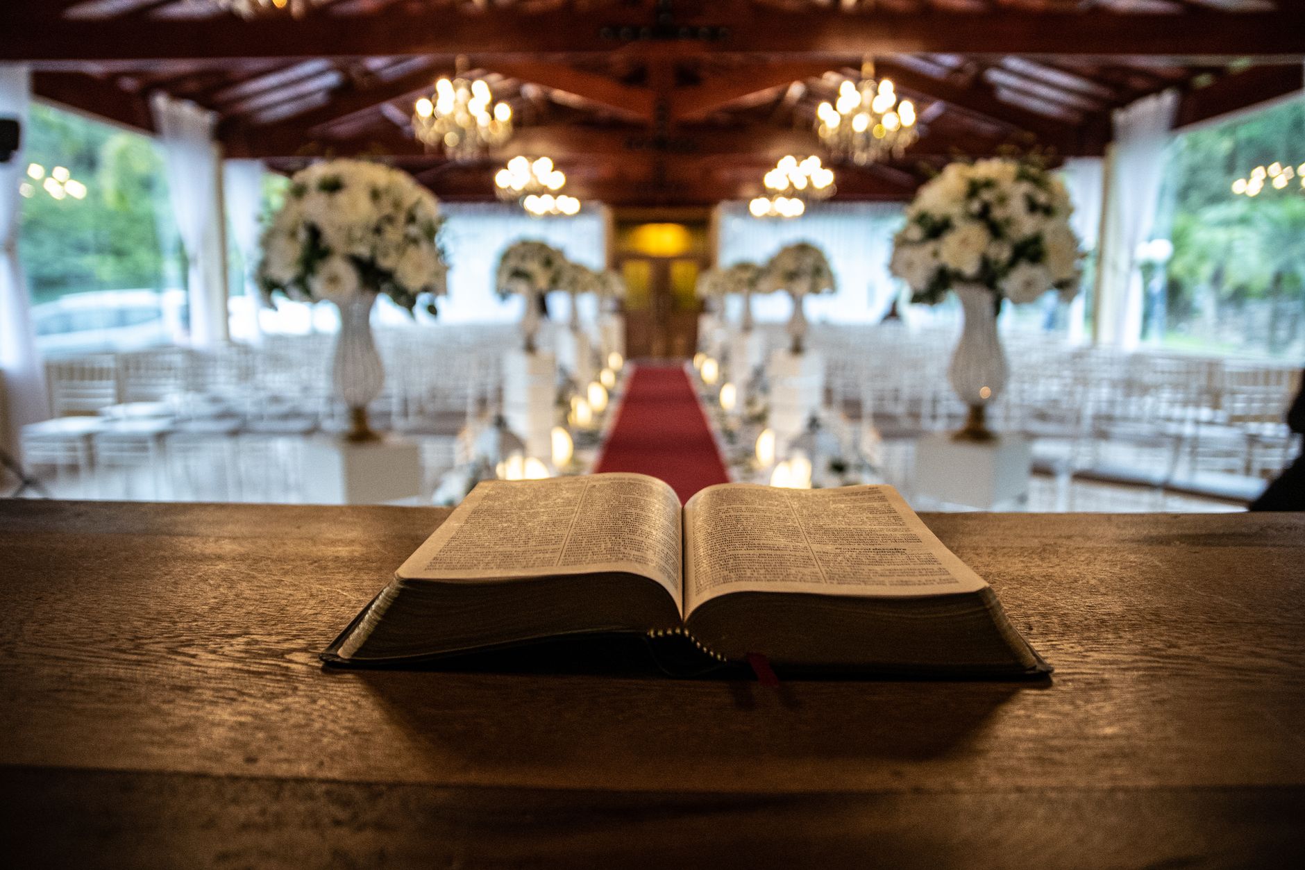 Beautifully decorated indoor wedding venue featuring a Bible and elegant floral arrangements.