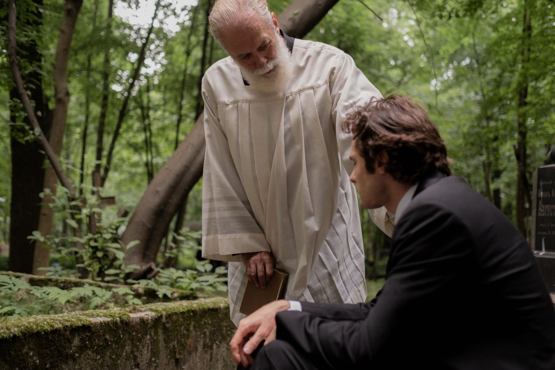 A gentle pastoral scene of sympathy and support in a serene forest setting.