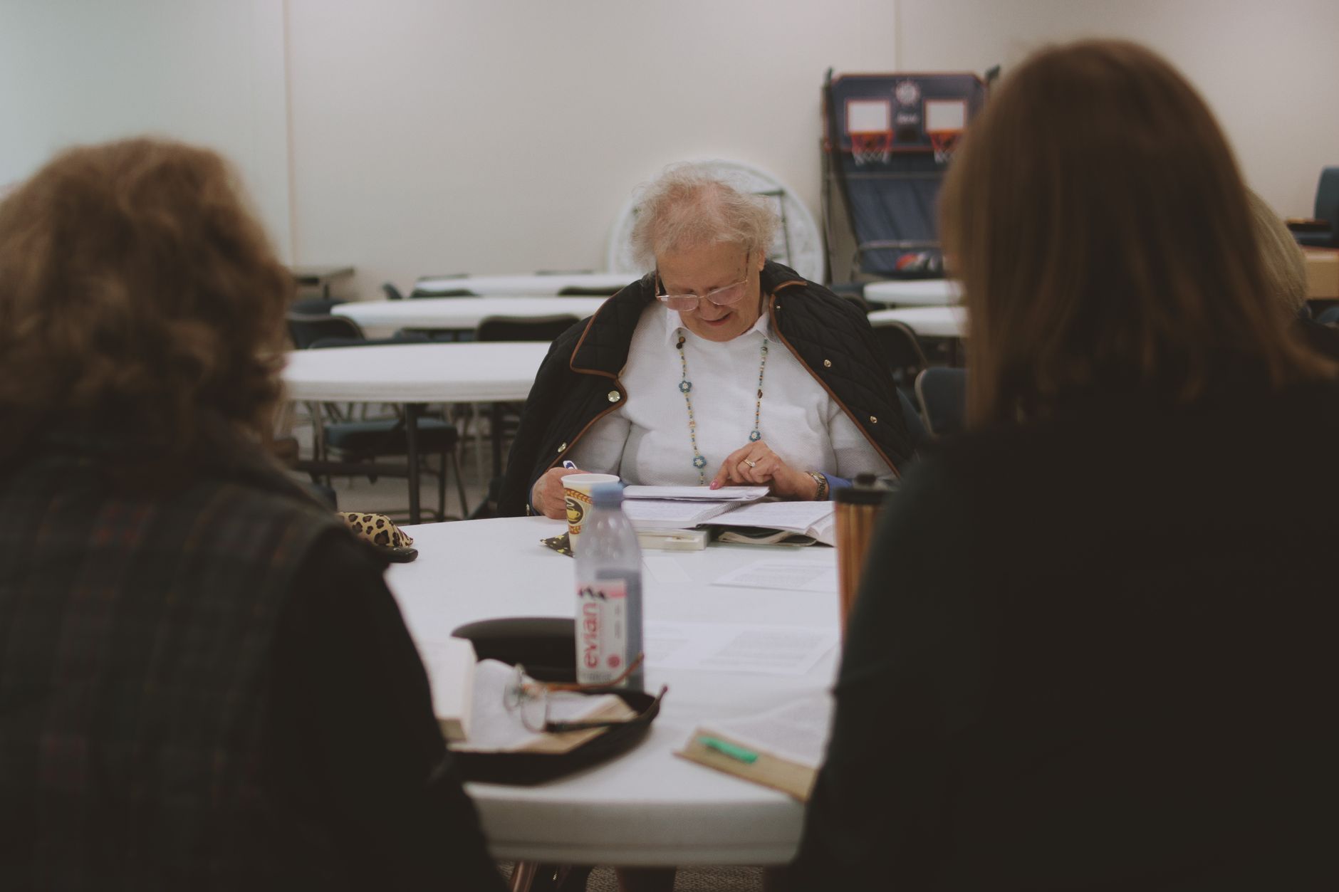 Older women engaging in a Bible study community group session indoors.