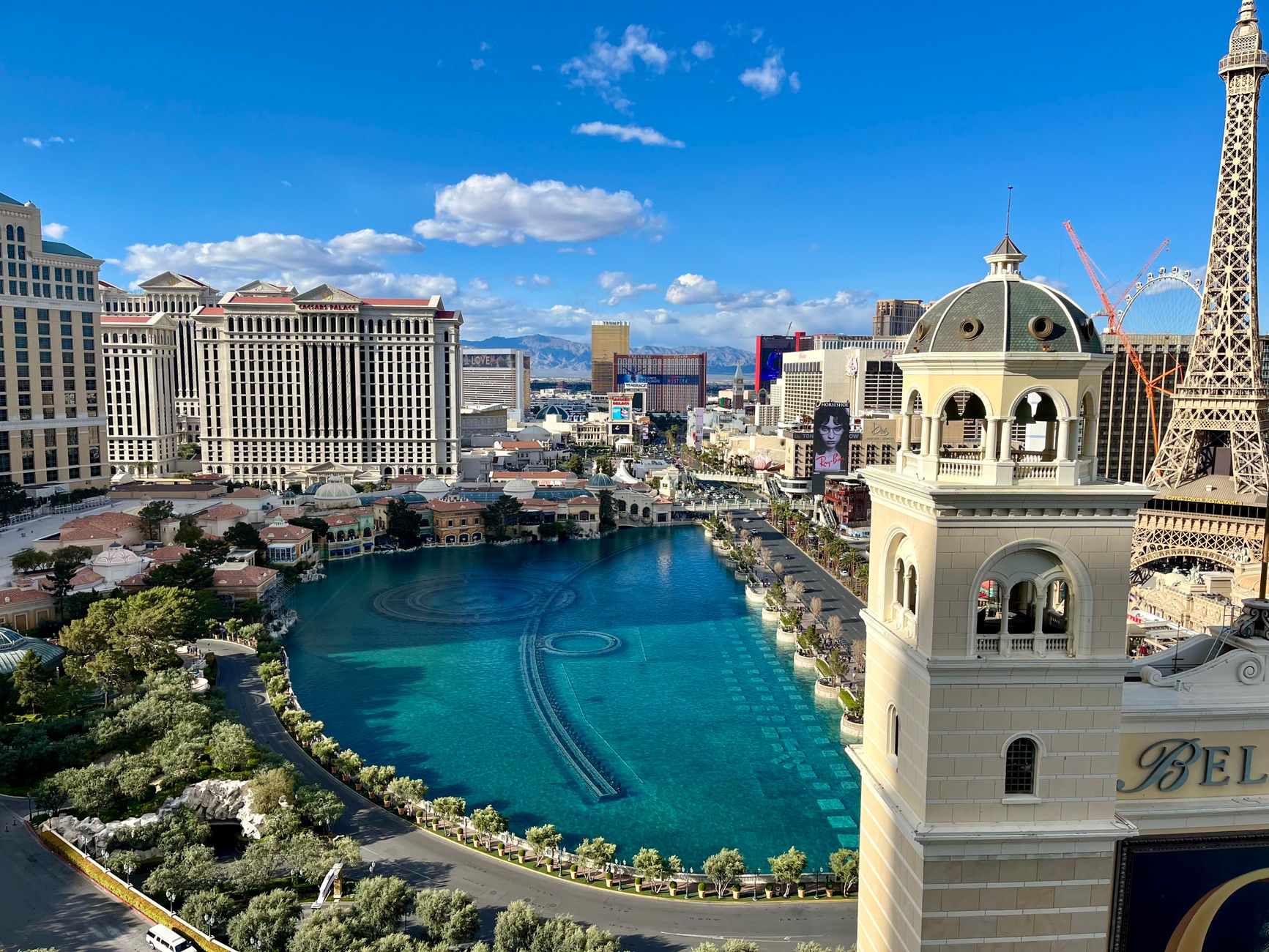 Stunning aerial view of Las Vegas Strip with Bellagio Fountains and Paris Hotel Eiffel Tower under clear skies.