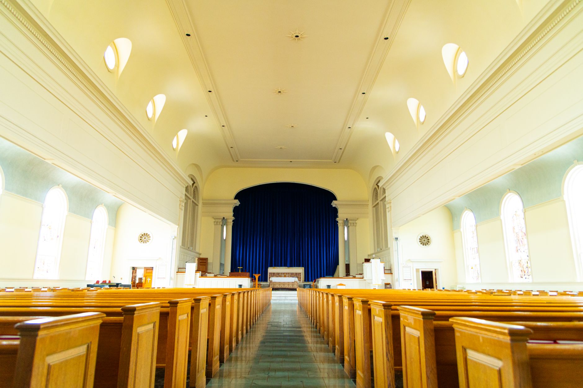 Elegant interior of a historic church in Gettysburg with wooden pews and blue drapery.