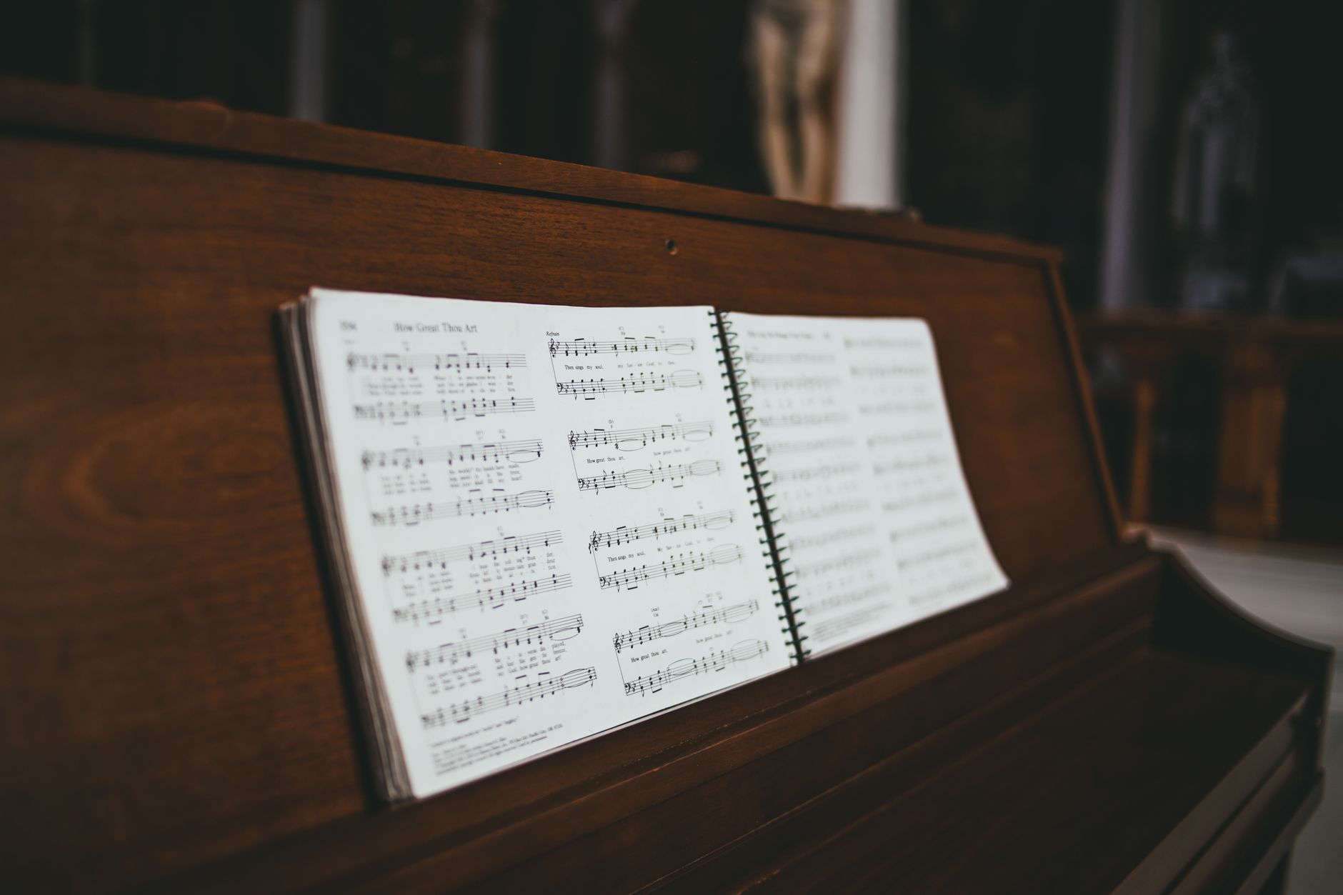 Elegant wooden piano with open sheet music, highlighting musical notes and creativity.