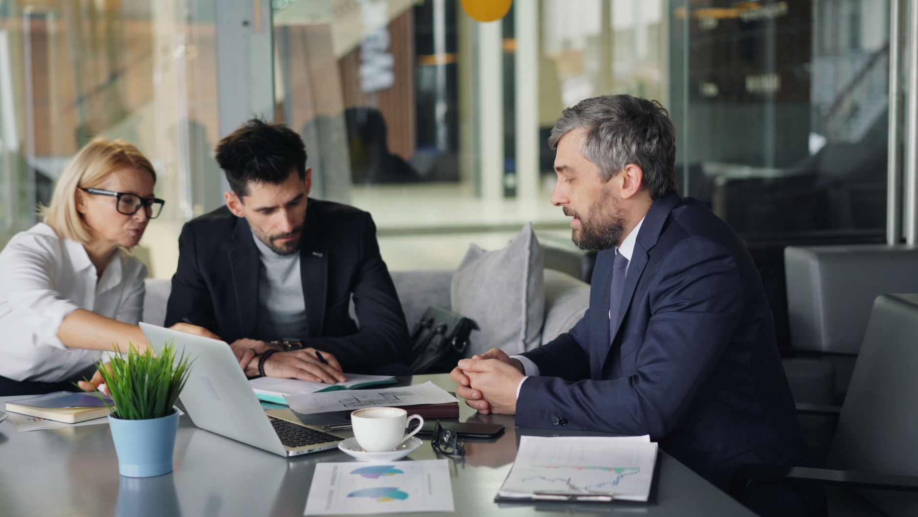 Líderes ministeriais analisando relatórios financeiros em laptops
