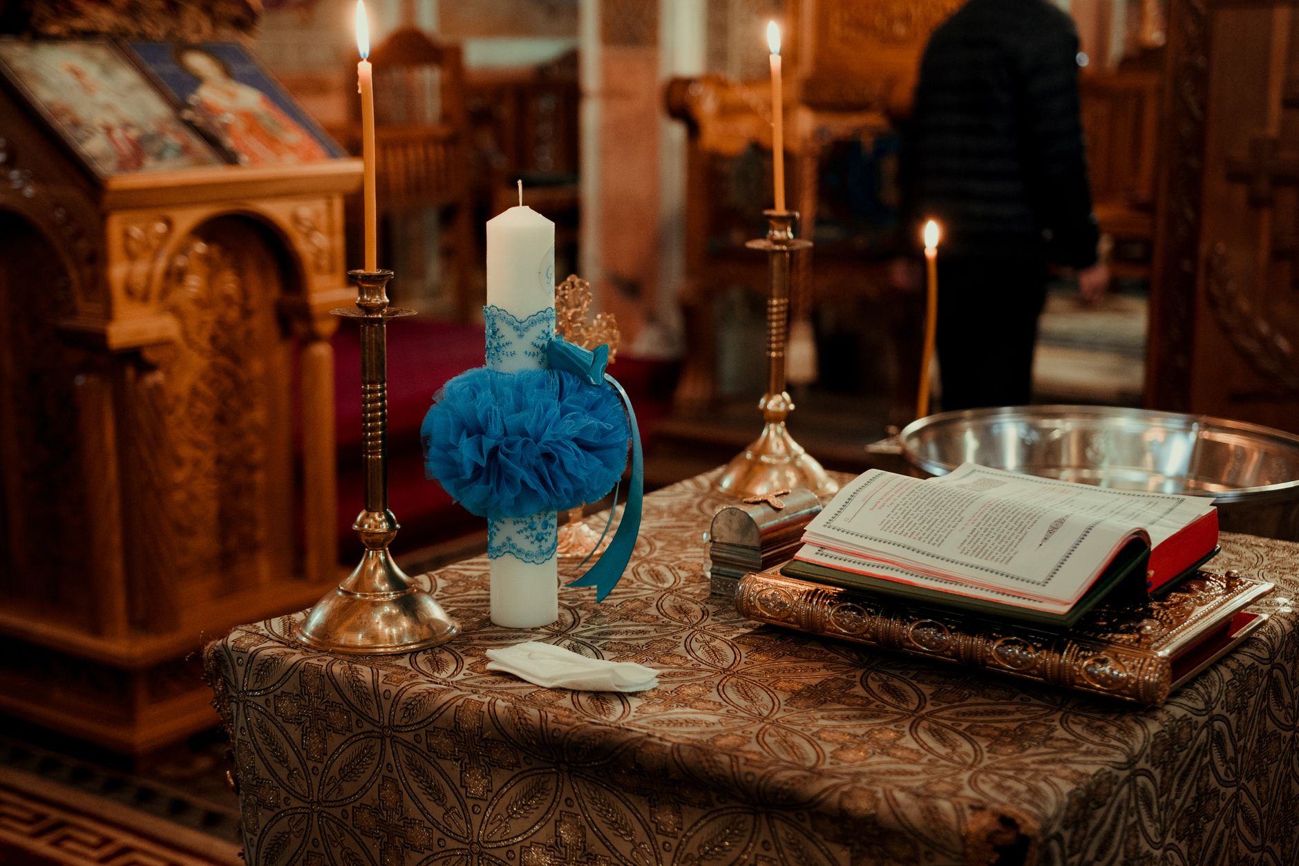 A beautifully decorated altar in a church featuring candles, an open book, and traditional wooden carvings.