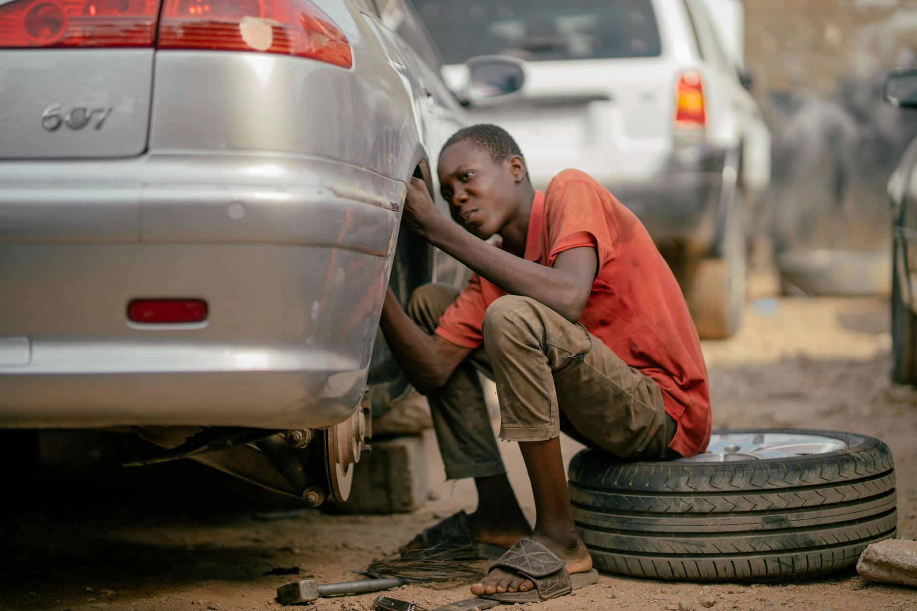 Mecânico instalando pneus novos em carro em oficina