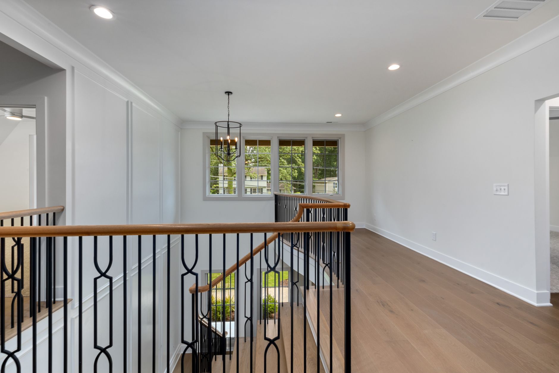 Spacious and elegant landing in a modern home with a view outside.
