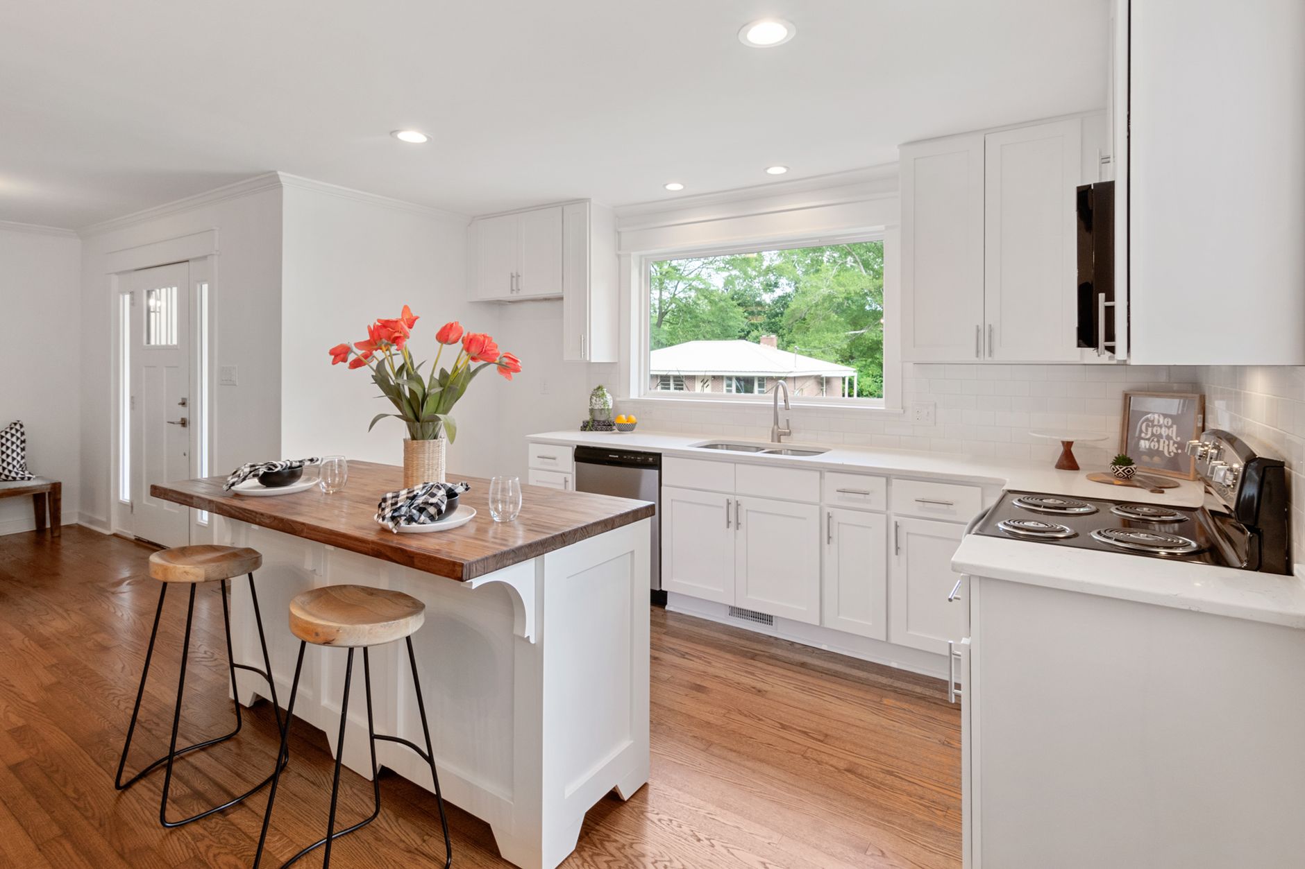 Bright contemporary kitchen with wood floor and island, inviting interior design.