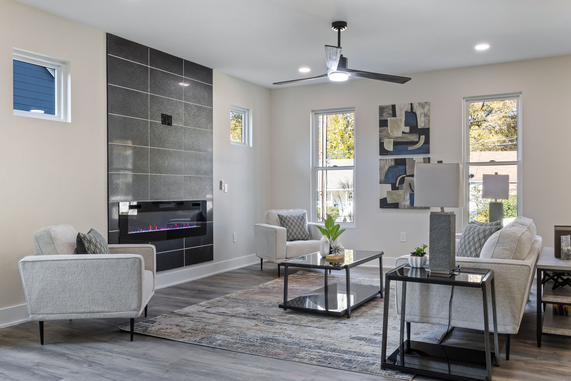 Stylish contemporary living room featuring a sleek fireplace, elegant furnishings, and natural light.