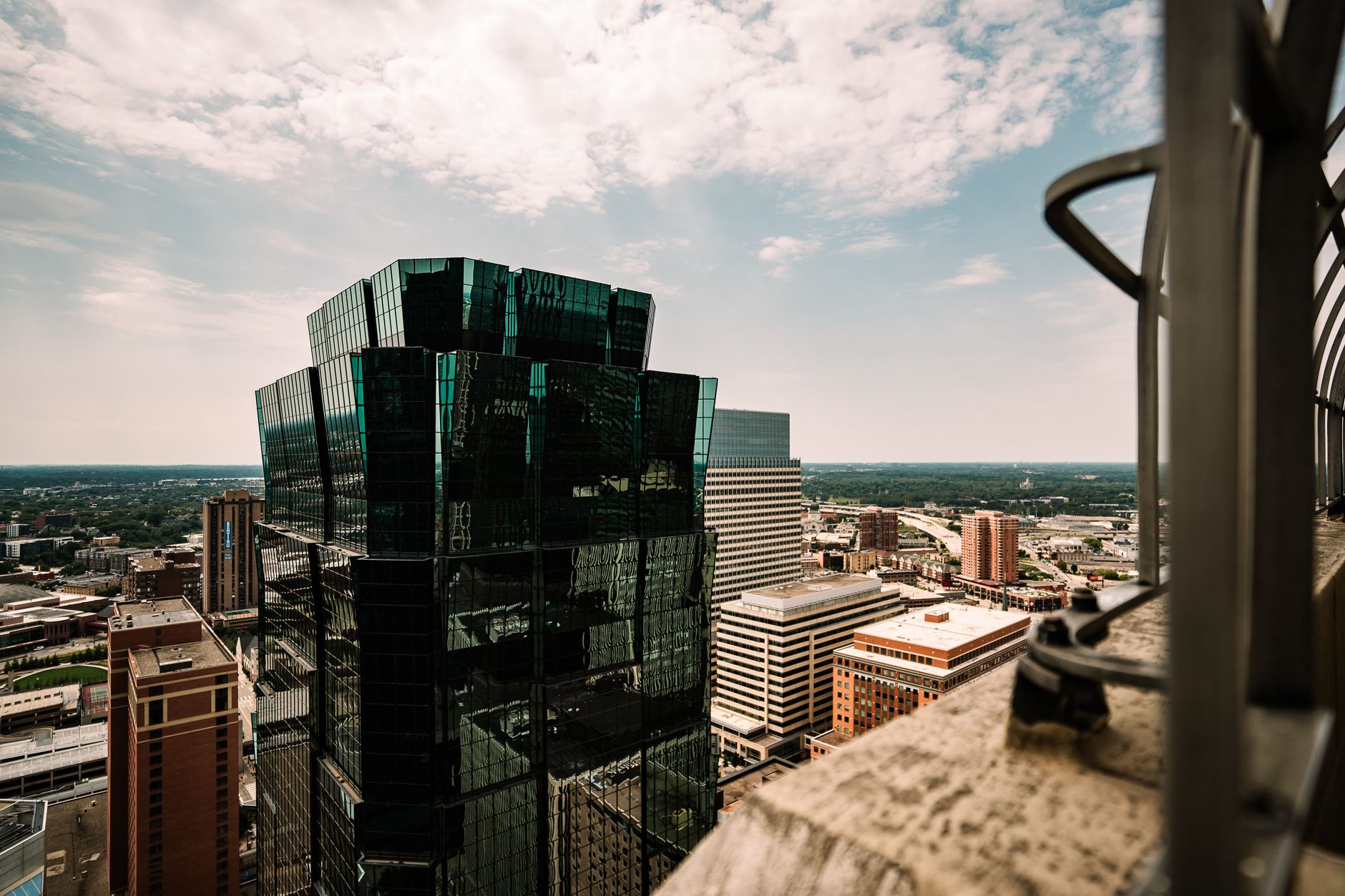 Aerial view of a modern skyscraper and cityscape in Minneapolis, Minnesota under a bright sky.