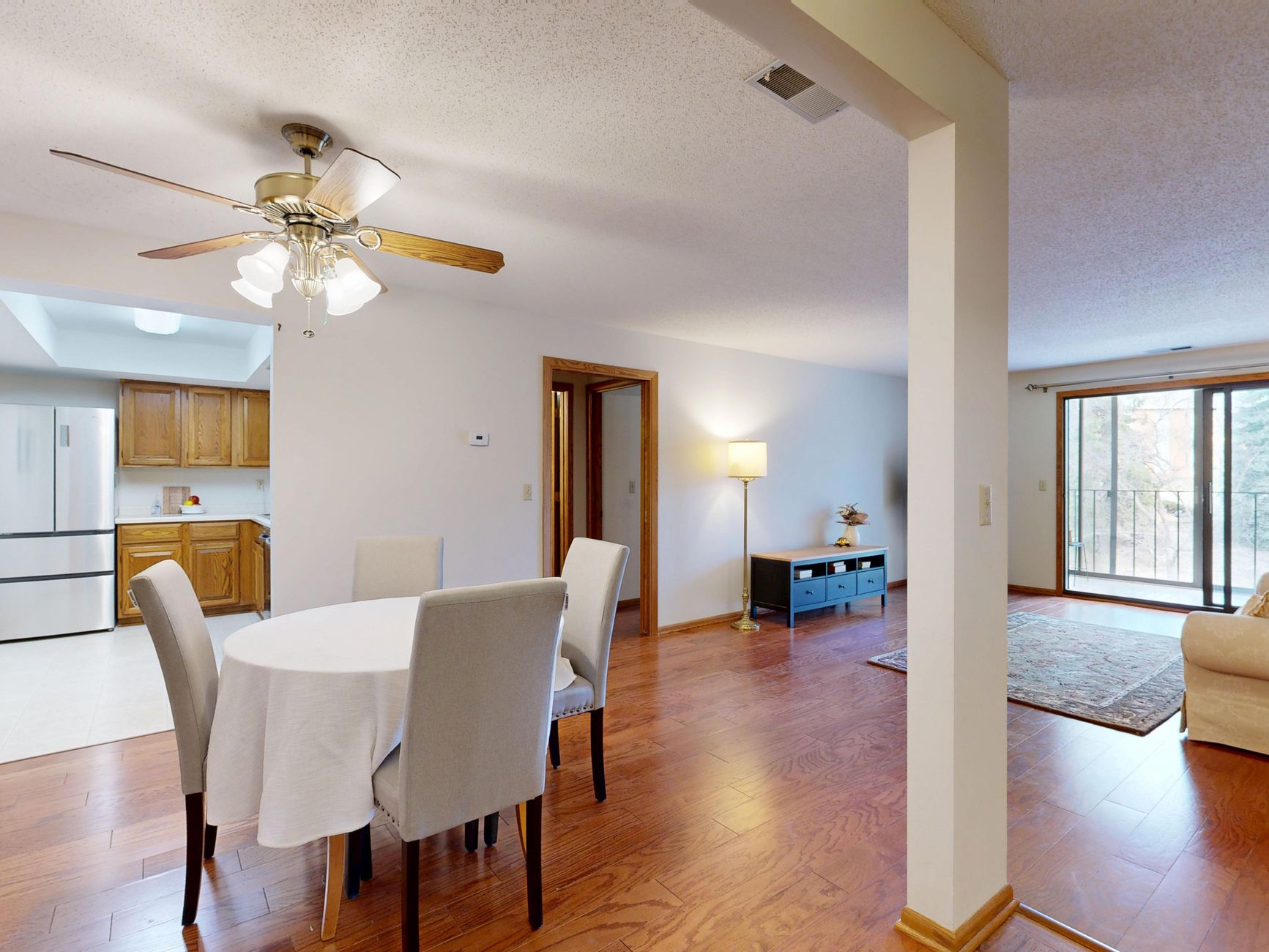 A modern open-plan living and dining area with wood flooring and natural light.