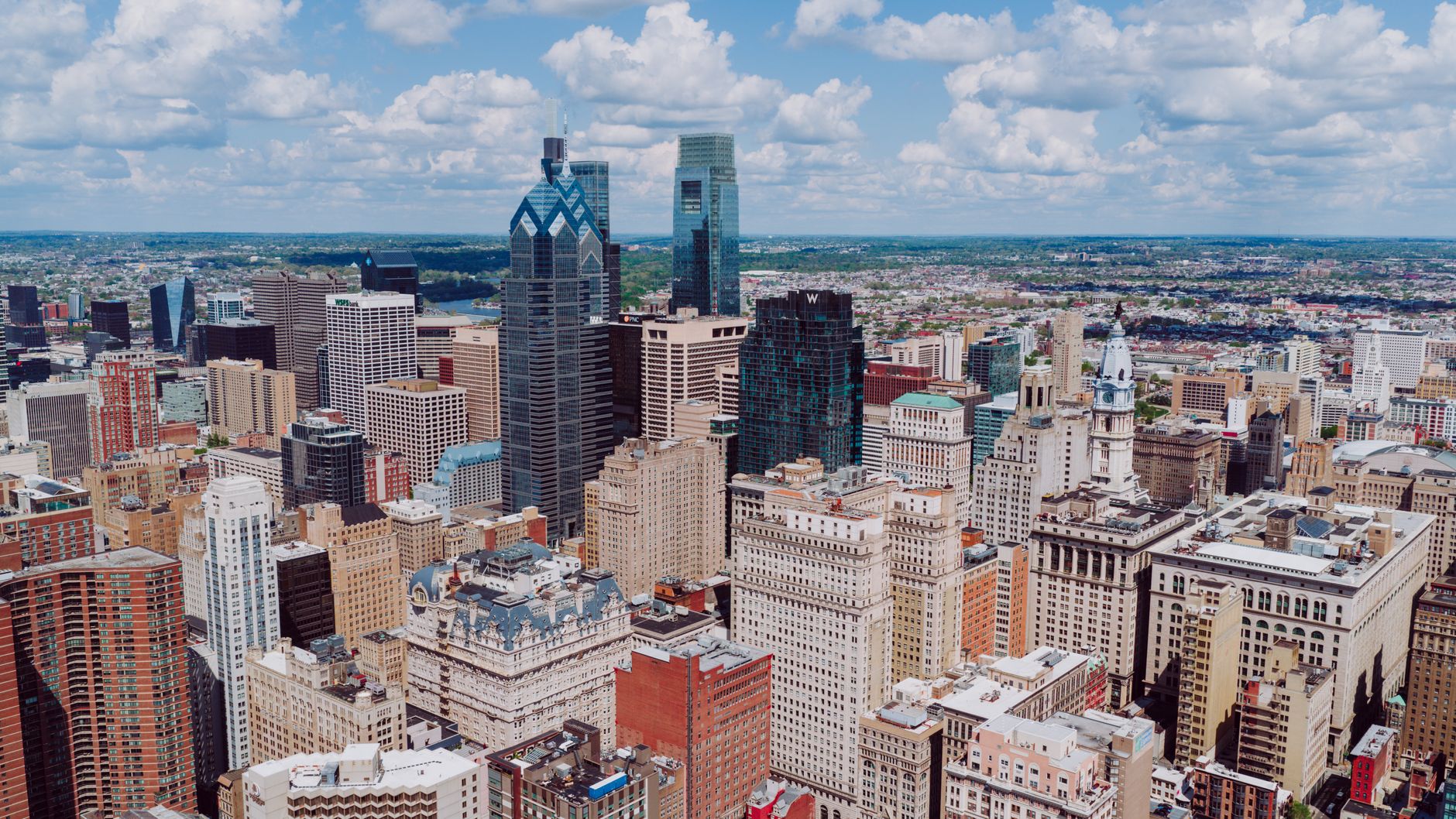 Breathtaking aerial view of the Philadelphia skyline, showcasing iconic skyscrapers and buildings under a blue sky.