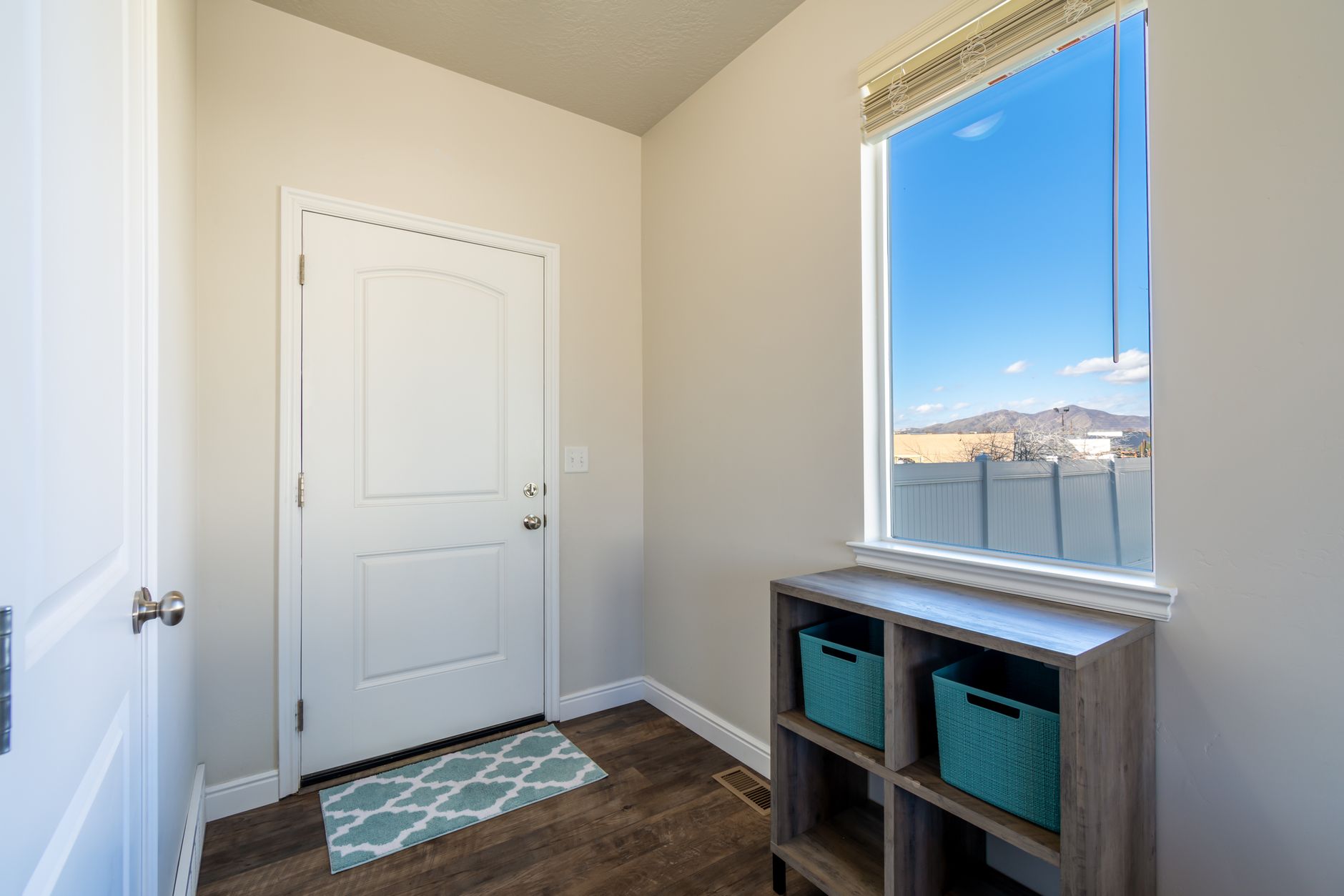 Contemporary entryway with door and shelf, showcasing natural light and clean design.