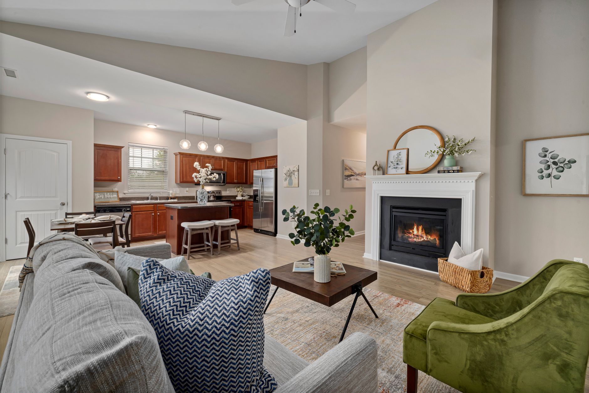 A stylish living room with a fireplace, modern furniture, and an open kitchen in view, creating a cozy ambiance.