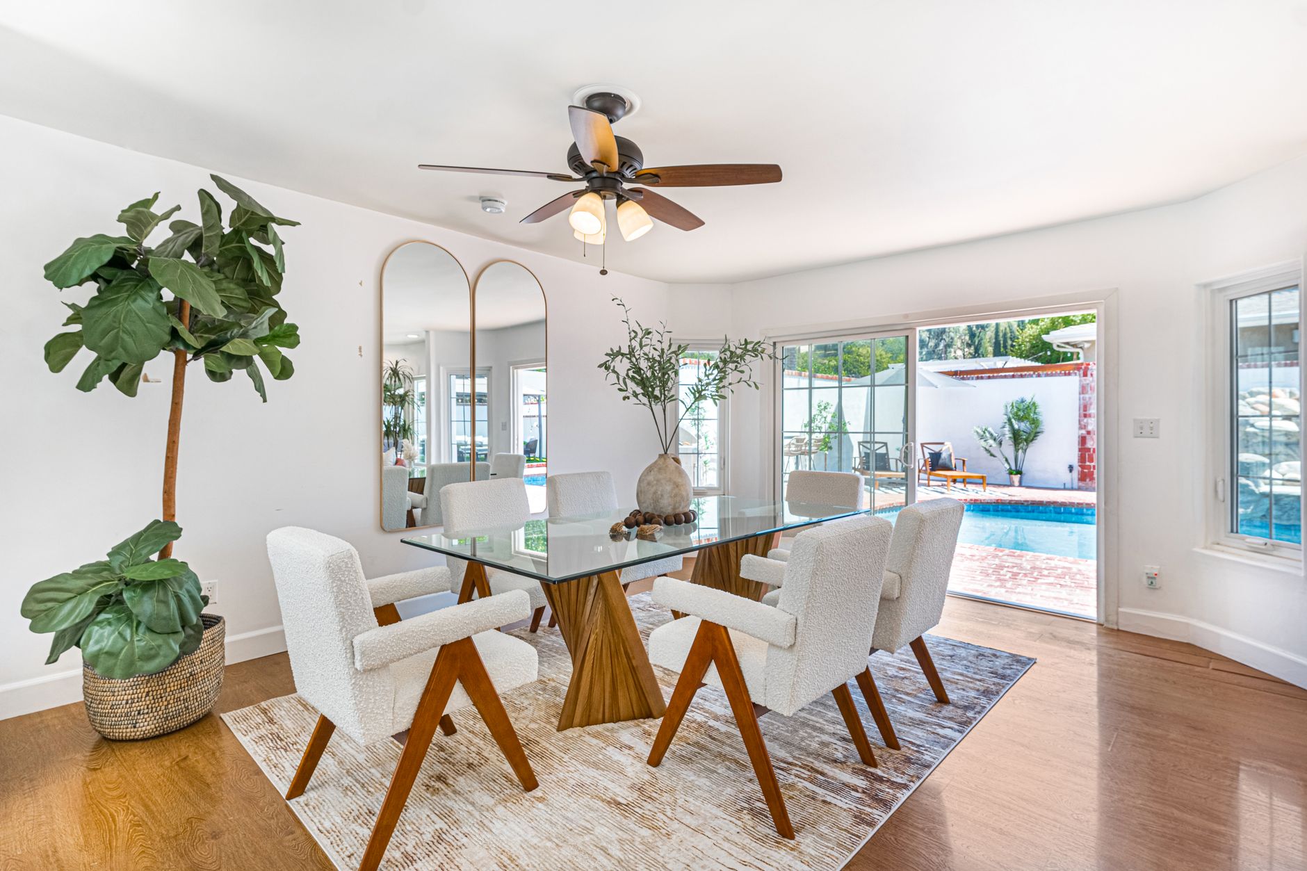 Bright contemporary dining room with pool view, stylish furniture, and modern design.