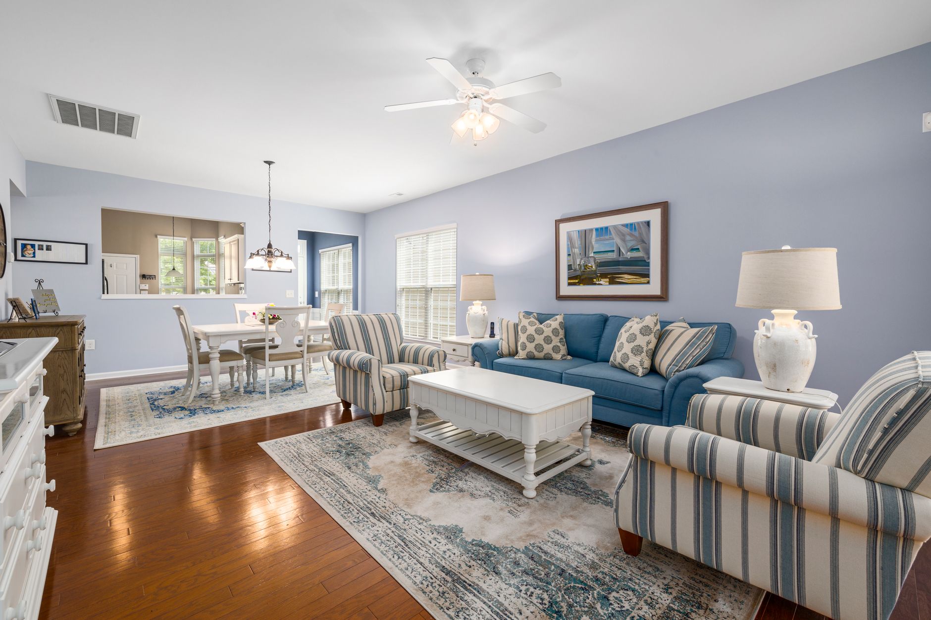 Elegant living room with blue sofas and striped chairs, perfect for home design inspiration.