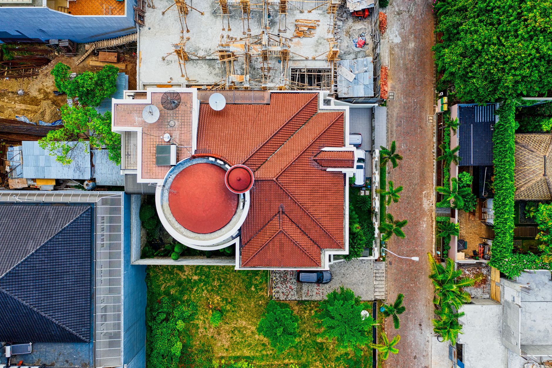 Aerial shot capturing a residential building with unique architectural design in a vibrant urban setting.