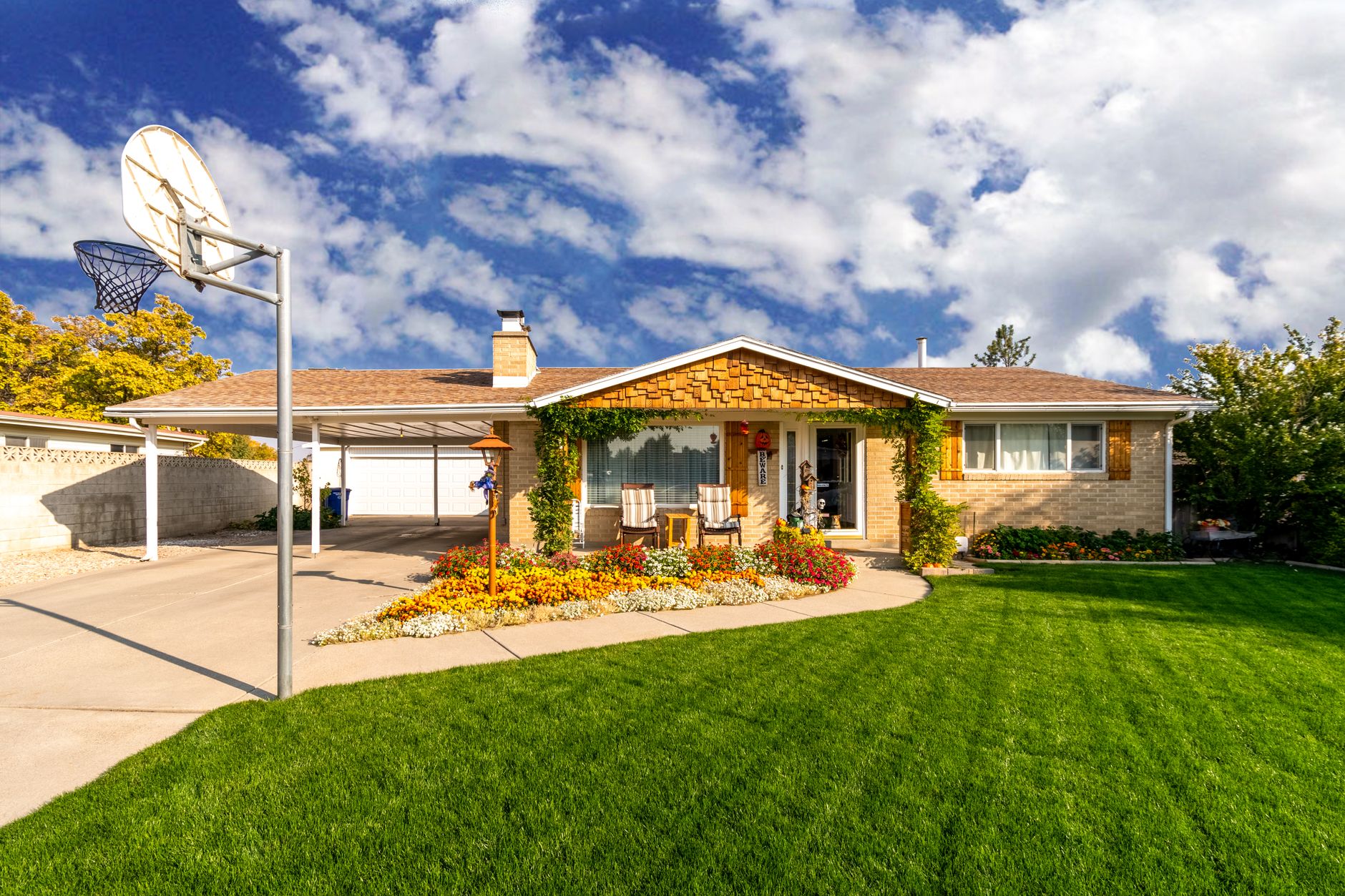 A picturesque suburban home with a green lawn and clear blue sky, captured in daylight.