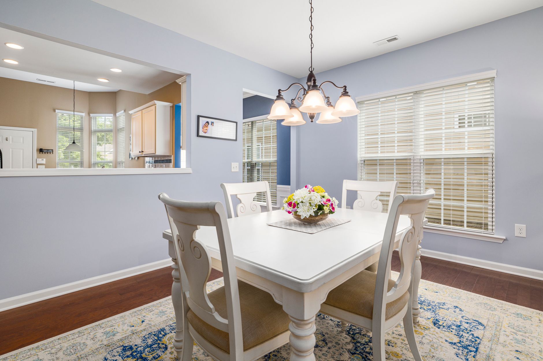 Bright and cozy dining room with elegant decor and white furniture.