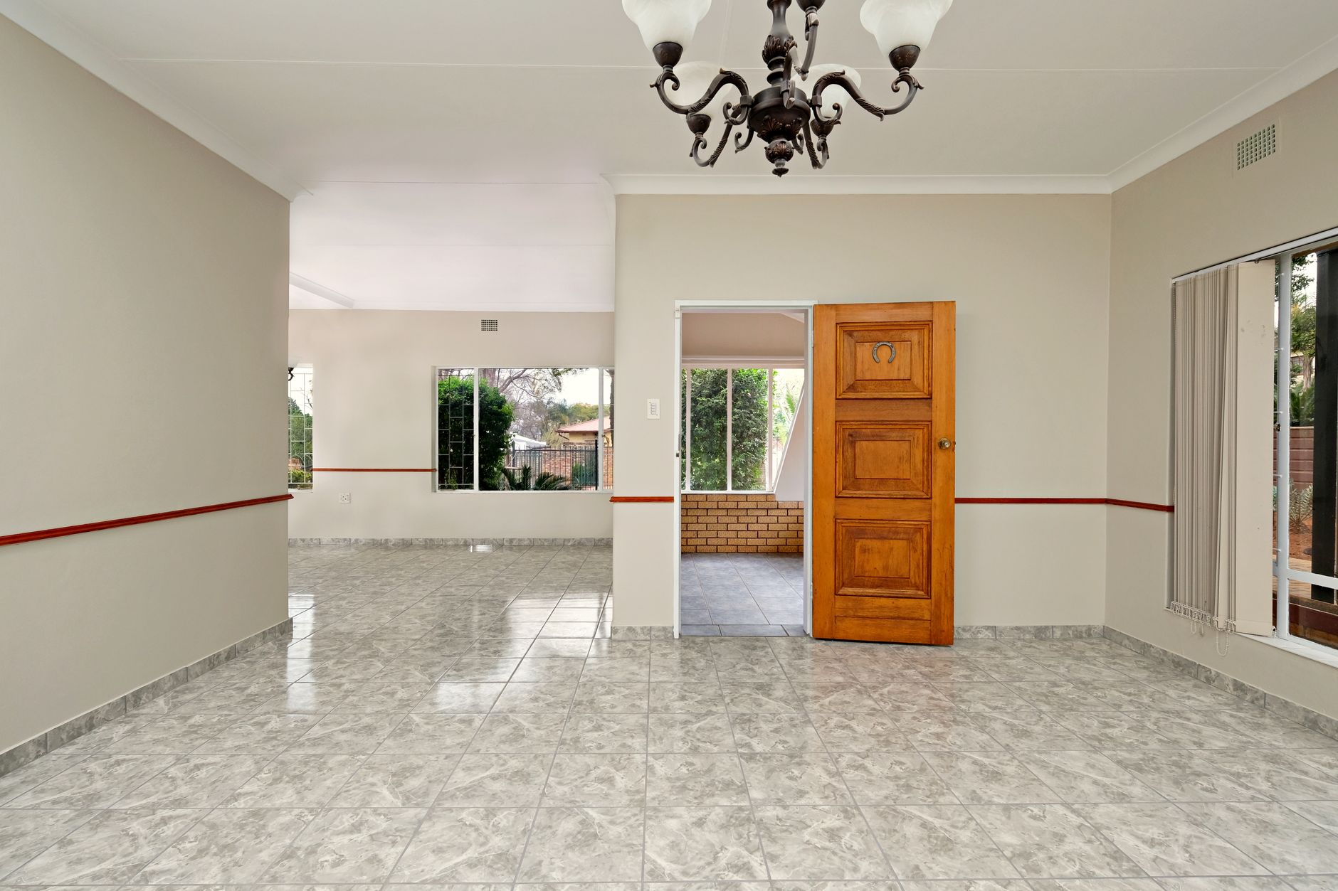 Unfurnished room in Pretoria with chandelier and tiled floor.