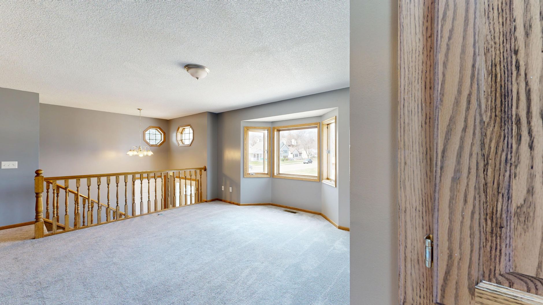 Spacious unfurnished room with carpet and large bay window view.