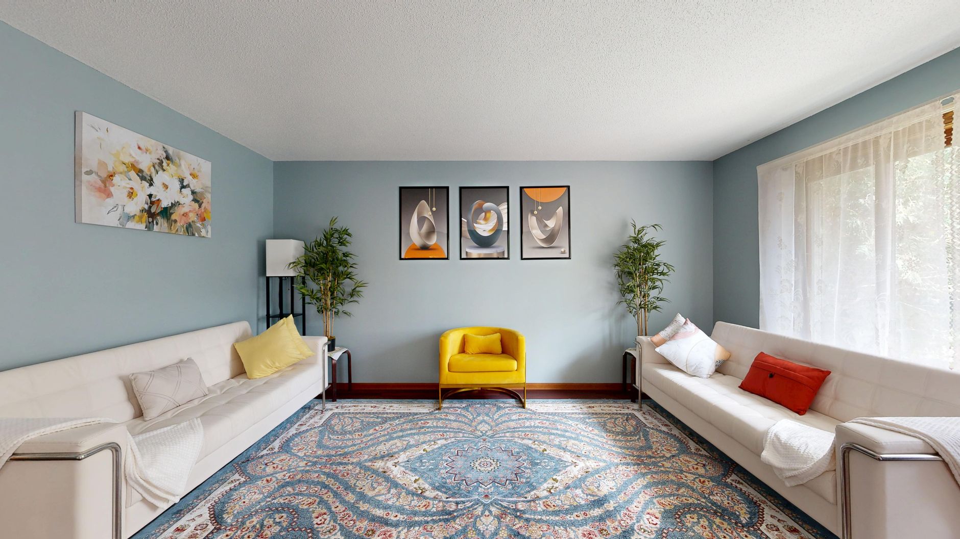 Chic living room with blue walls, elegant furnishings, and artwork decor.