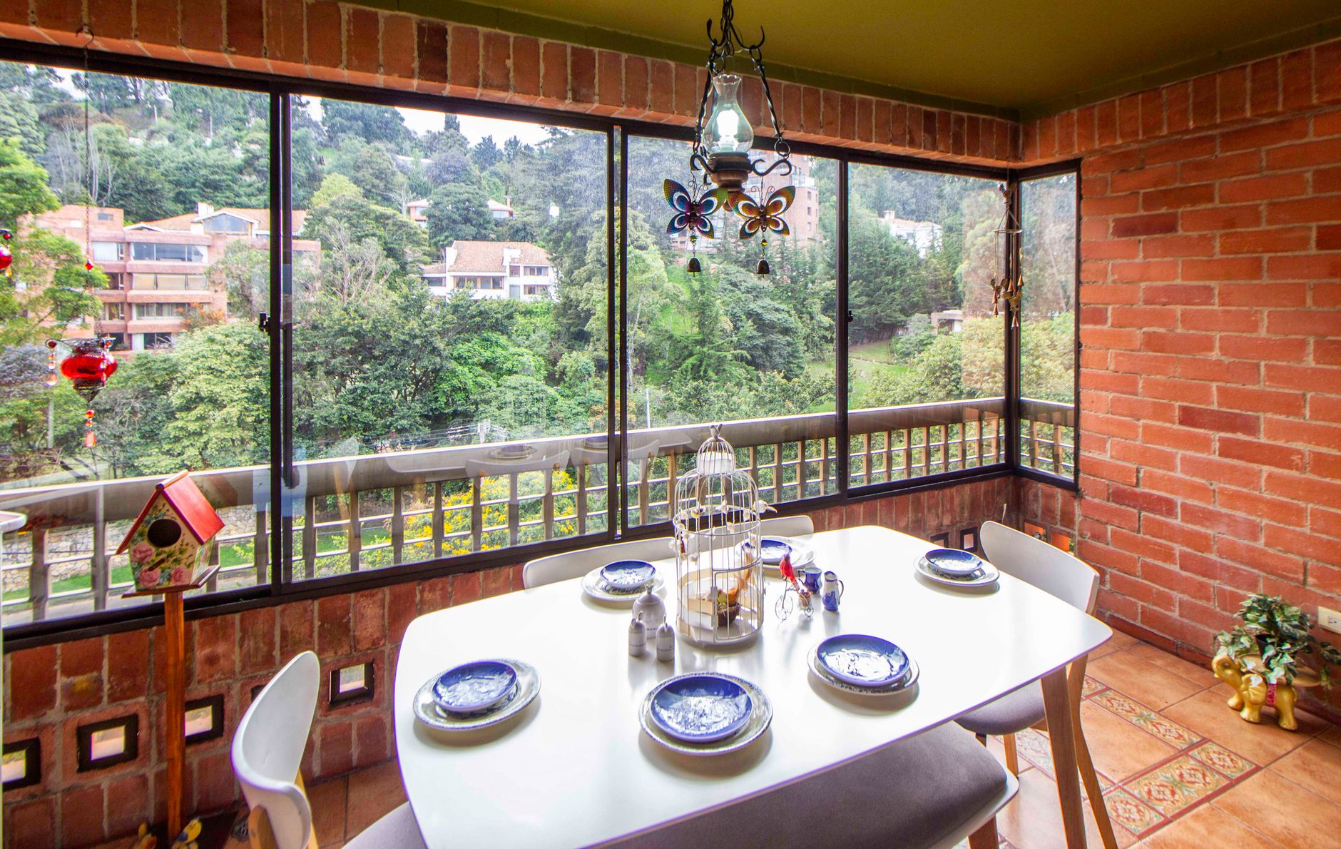 Bright brick-walled dining space with a scenic view and elegant decor.