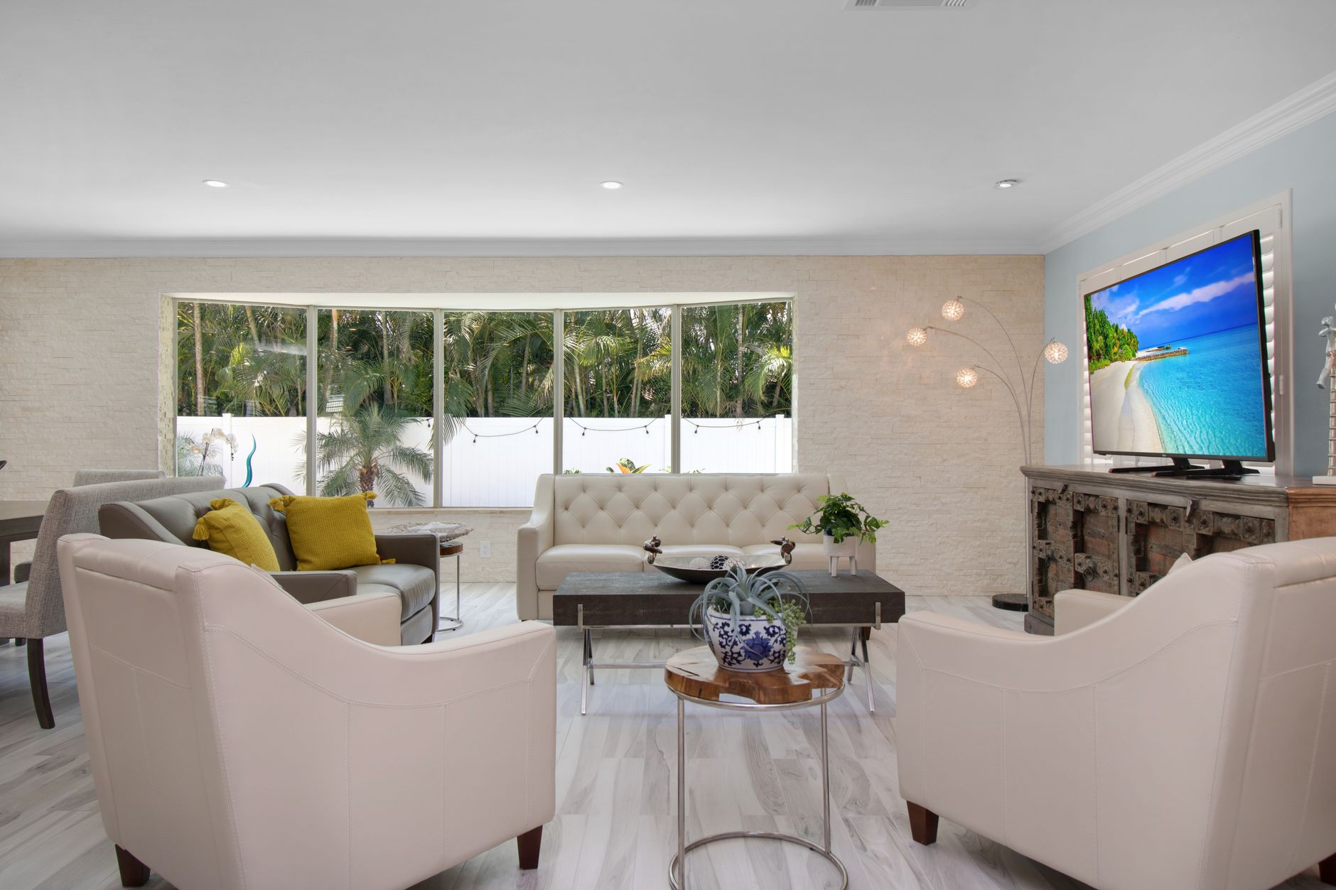 Bright and cozy modern living room with elegant furnishings and a large window looking outside.