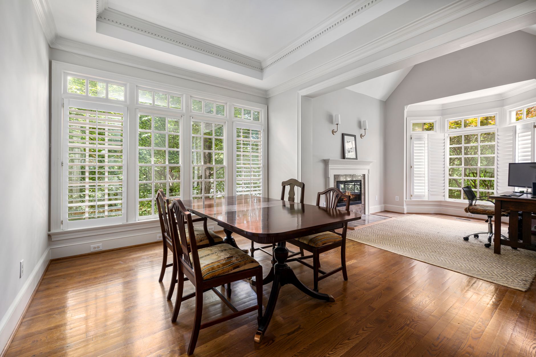 Spacious dining area with wooden furniture and large windows bringing in natural light.