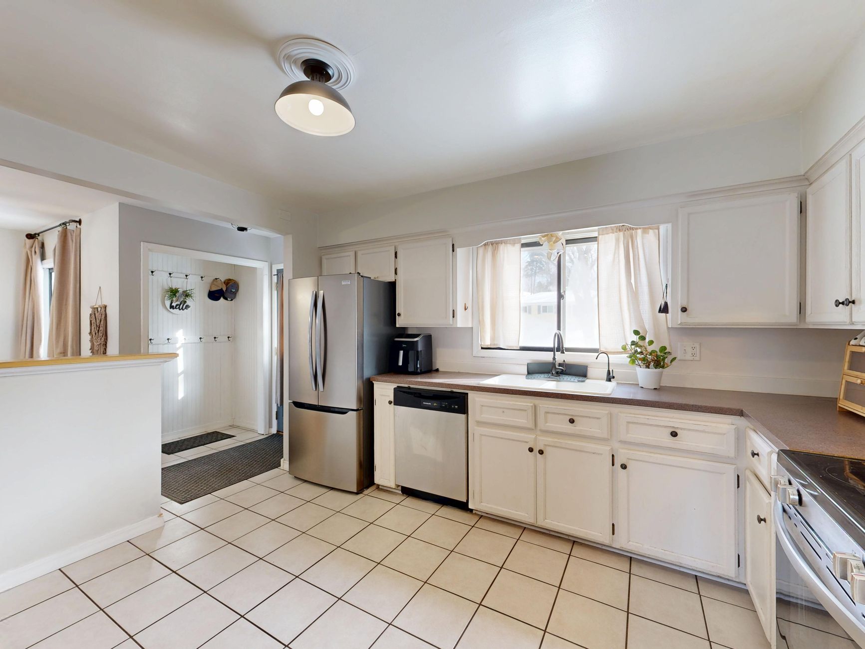 Spacious kitchen featuring white cabinets and stainless steel appliances, perfect for home cooking.