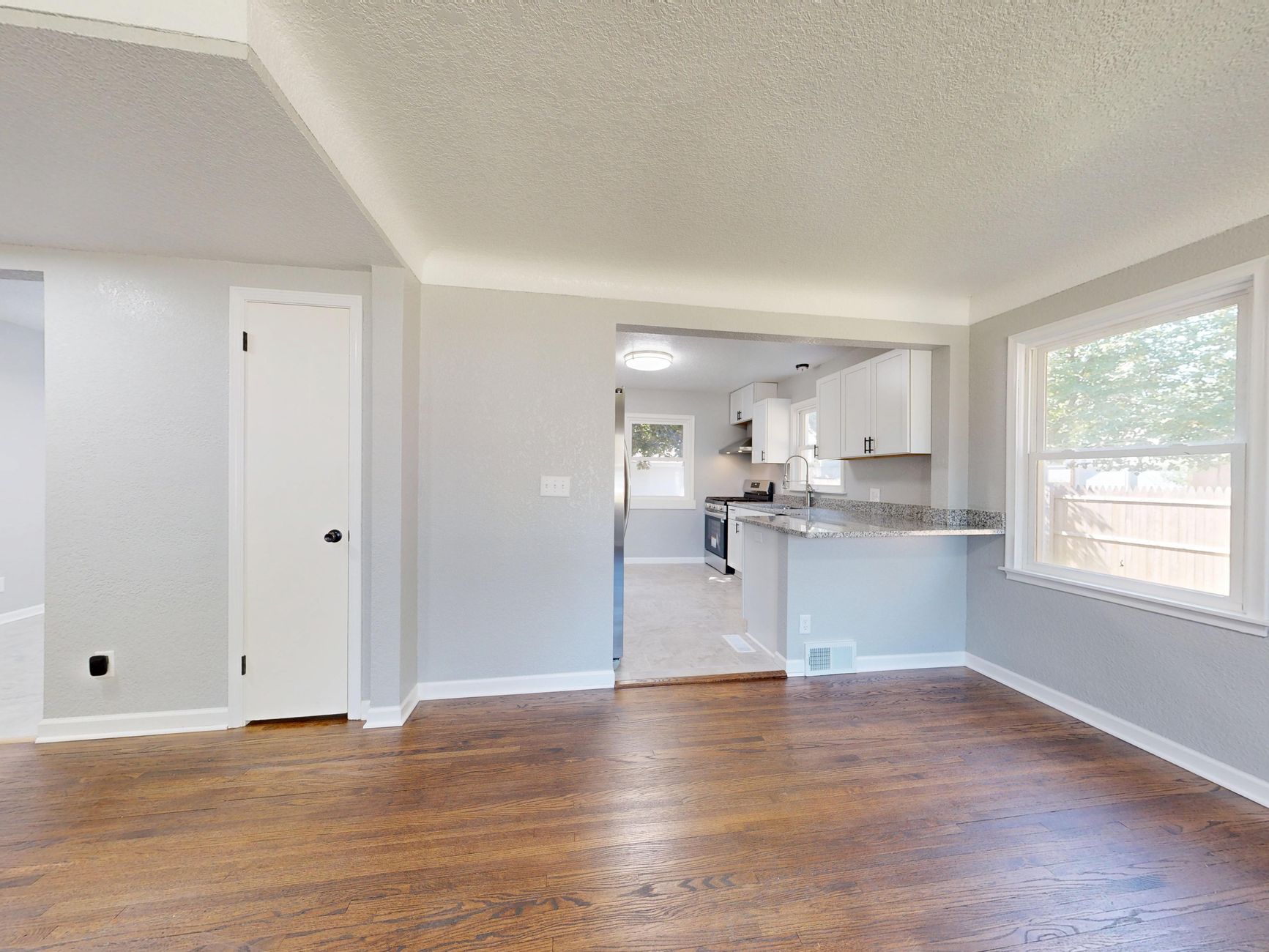 Modern kitchen and dining area with hardwood floors and natural light.