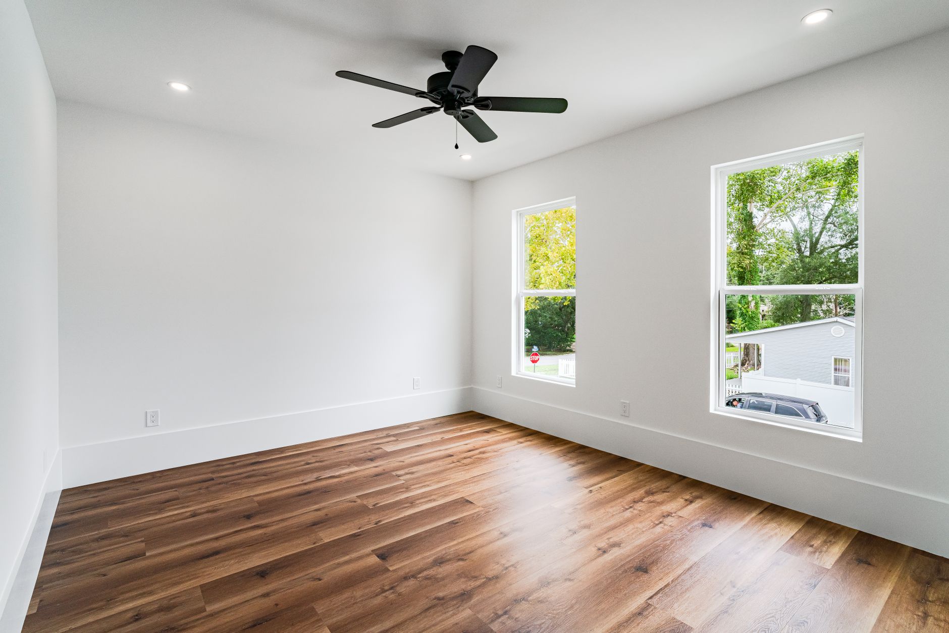 Empty room with wooden floors and ceiling fan in a New Orleans home, perfect for real estate listings.
