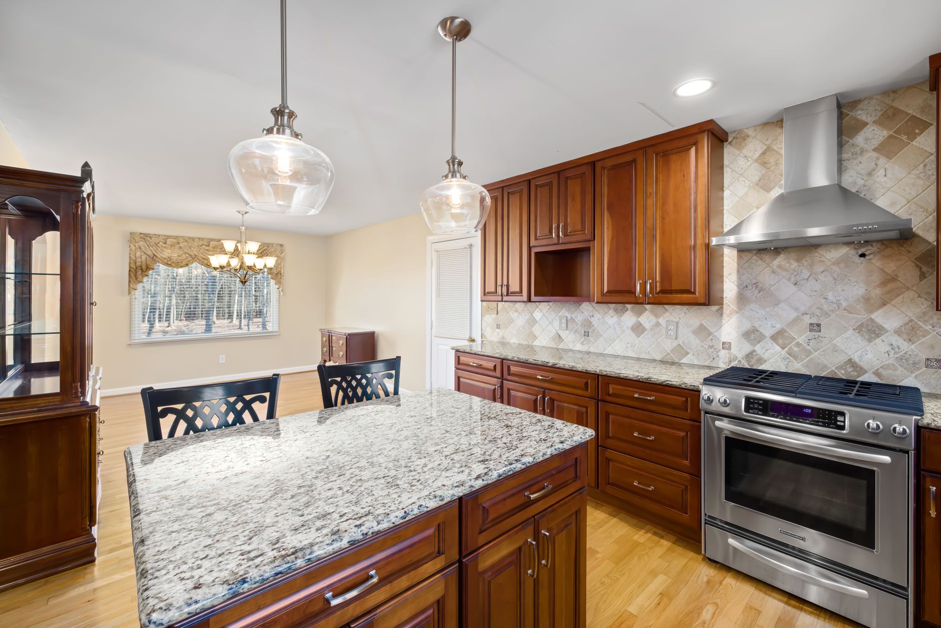 Spacious modern kitchen featuring granite countertops and wooden cabinets.