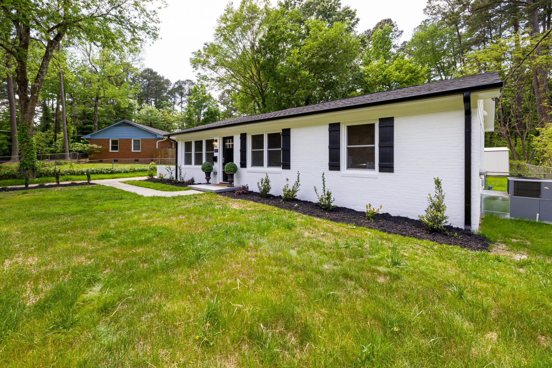 A modern suburban home with a lush green lawn and landscaped garden.
