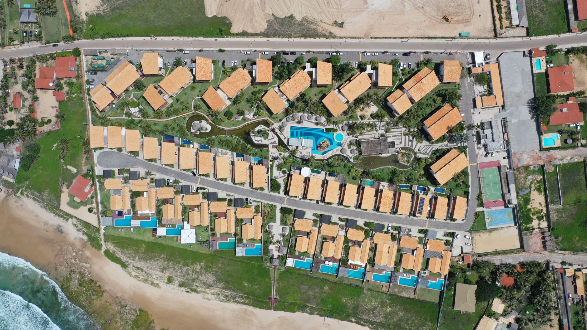 Drone shot of a residential complex by the beach in Taiba, Brazil, highlighting modern architecture.
