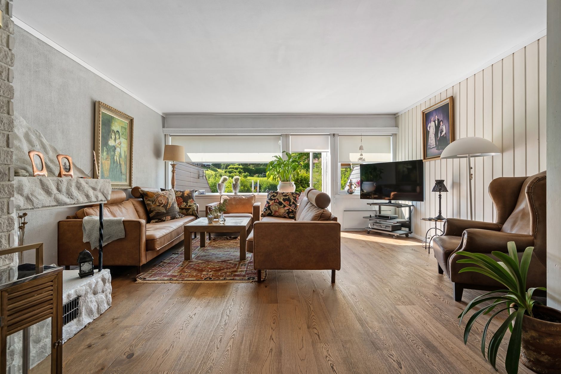 Spacious living room with modern decor, leather sofas, and natural lighting.