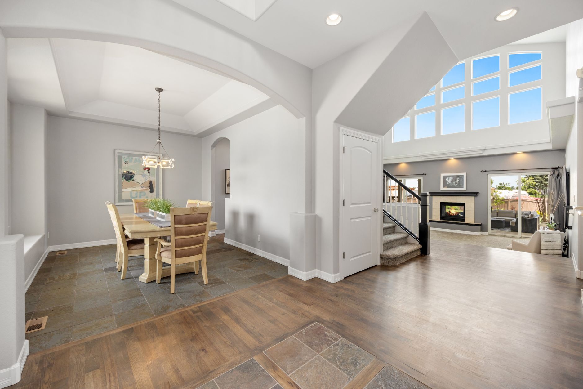 Bright, spacious open-concept dining and living room with modern design and fireplace.