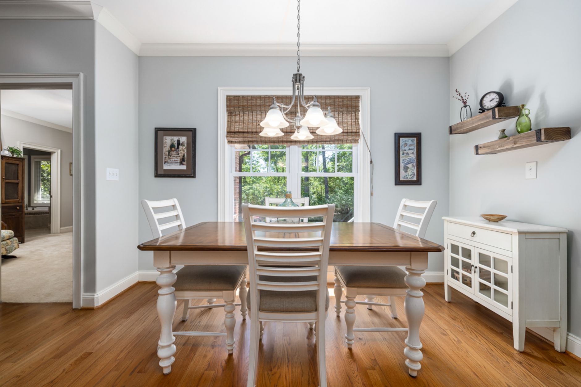 Modern dining room with wooden furniture, natural light, and stylish decor.