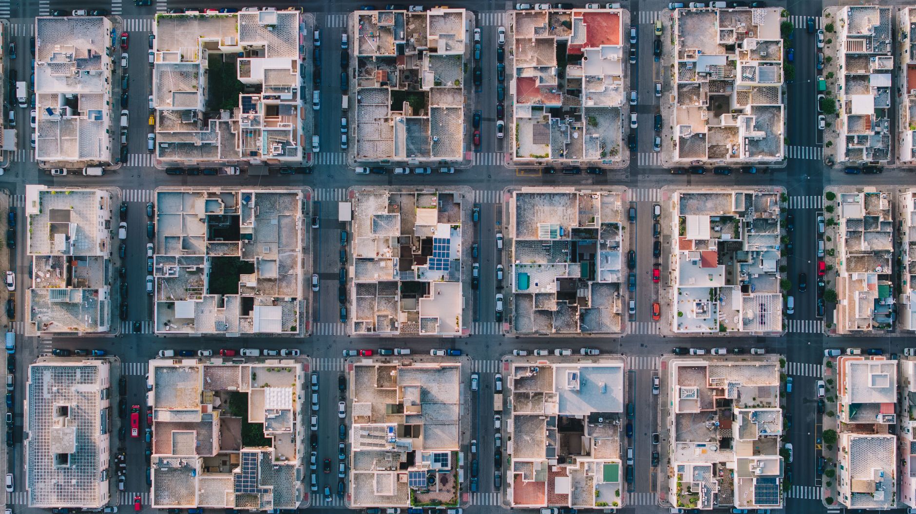 Drone shot of residential rooftops in Monopoli, Puglia, Italy, showcasing urban grid pattern and architecture.