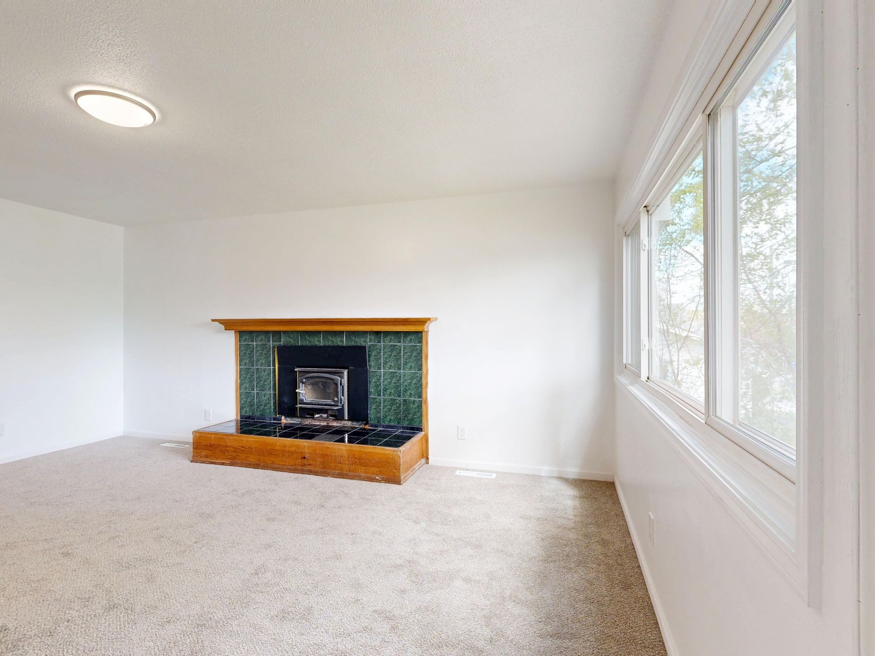 Spacious living room featuring a modern fireplace and large windows.