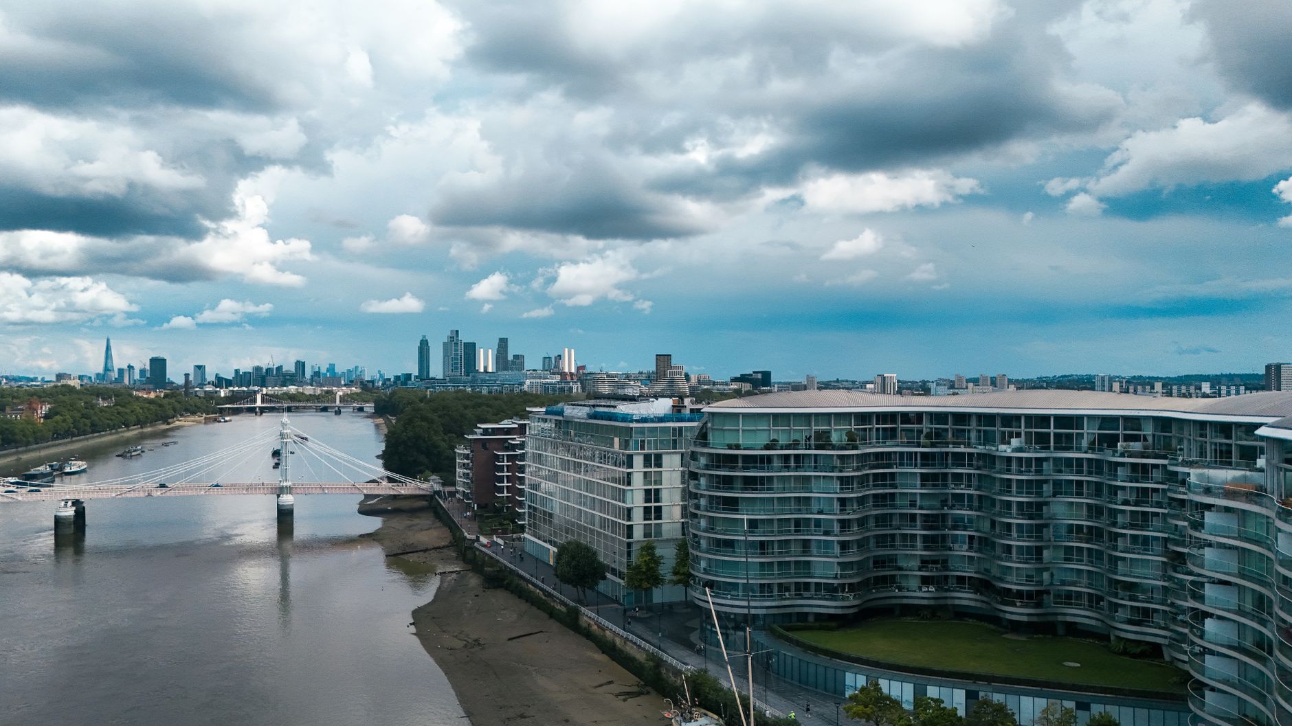 Aerial view of London's riverfront with modern architecture and city skyline.