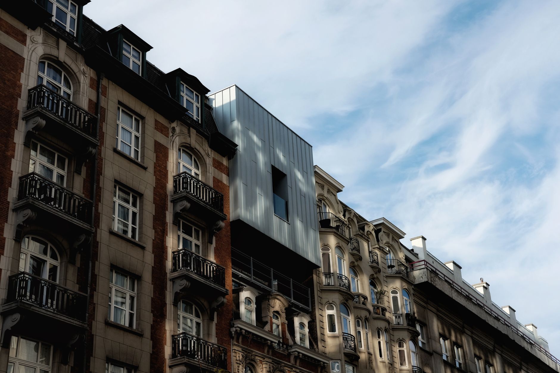 View of Brussels architecture blending classic buildings with modern design under a clear sky.