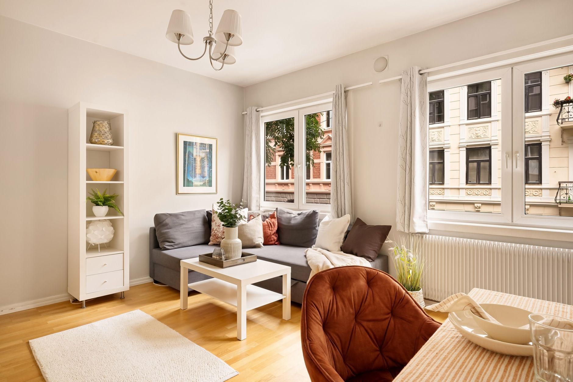 A bright and modern living room with stylish furniture and ample natural light through large windows.