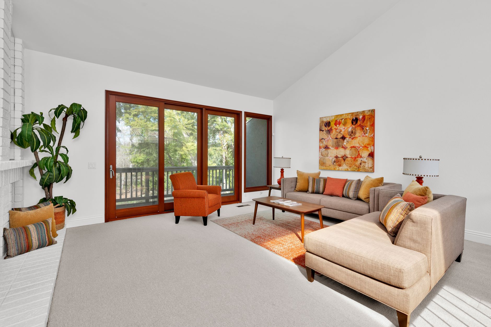 Bright and spacious living room featuring modern design with large windows and colorful accents.