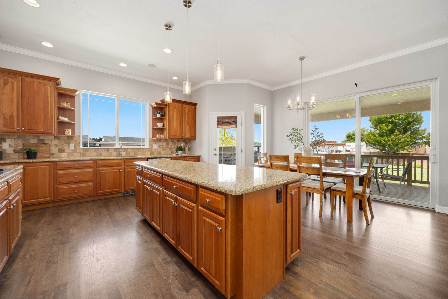 Bright and spacious kitchen with wooden cabinets and a dining area.