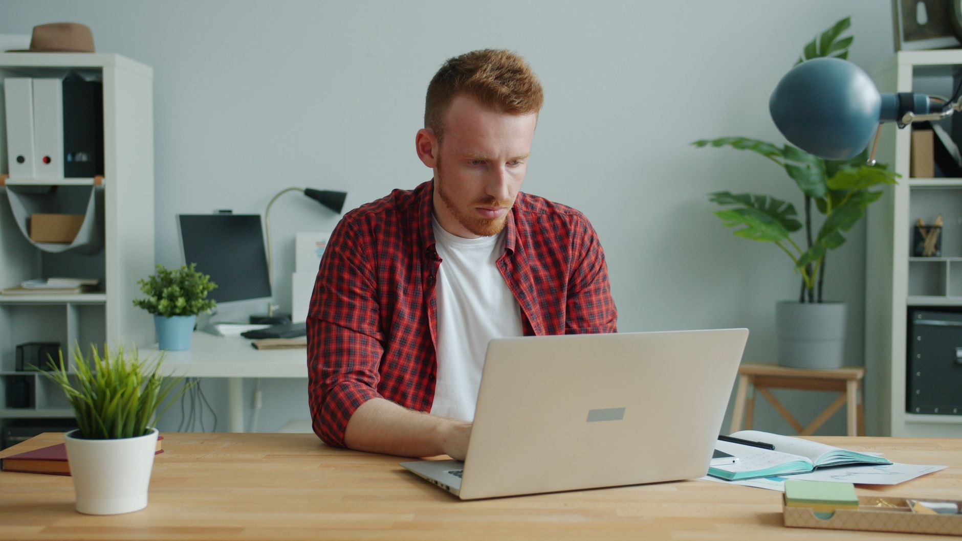 Professional reviewing enhanced property photos on laptop before publishing
